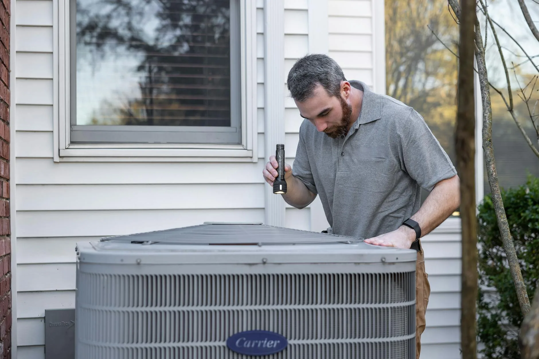 HVAC technician inspecting a residential air-conditioning system